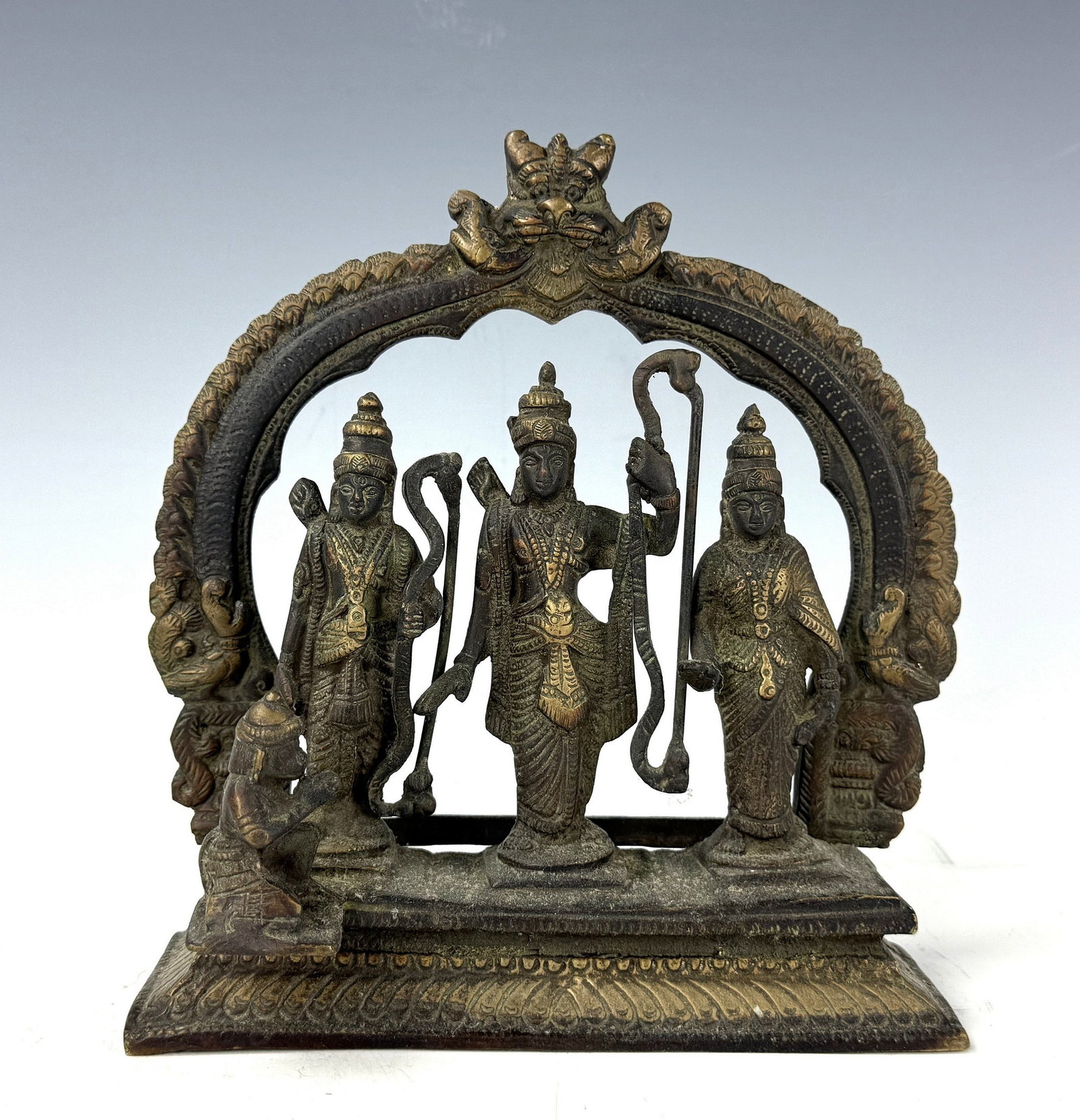 Ramdarbar India Gods Brass Statue Rama Sita Lakshmana Hanuman: This vintage brass Ram Darbar statue from India depicts Lord Rama, Sita, Lakshmana, and Hanuman under an arched fram. H20 cm(8 in.) x W19 cm(7.8in.)x D 9 cm(3.6 in.). Preview from June 22nd to 26th