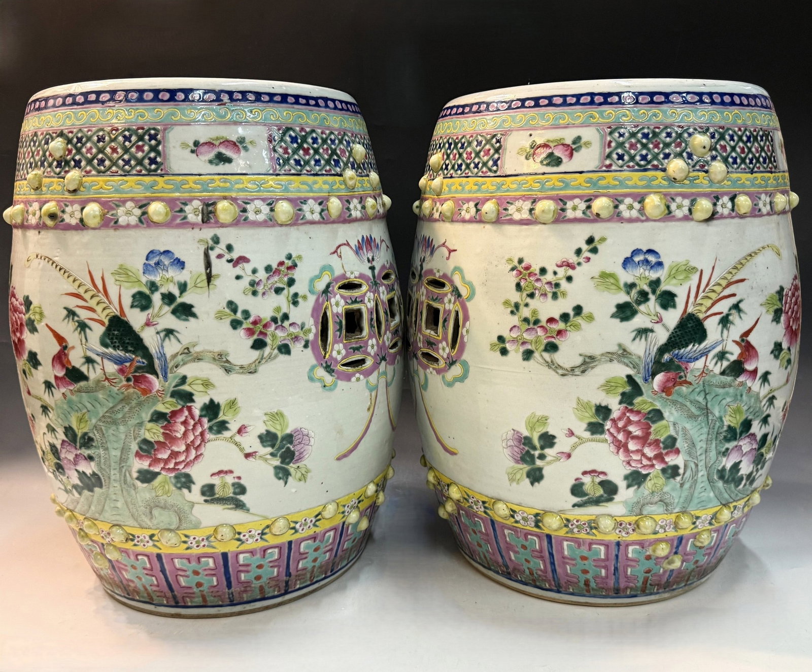 Pair of Chinese Antique Famille Rose Porcelain Garden Stools: Pair of Polychrome Porcelain Stools with Bird?and?Peony Decoration and Coin?Pierced Panels. H 45.7 cm(18 in.) x D 35.6 cm(14 in.)x 2. Preview from Aug 24th to 28th from 1:00 PM TO 5:00 PM Eastern Time