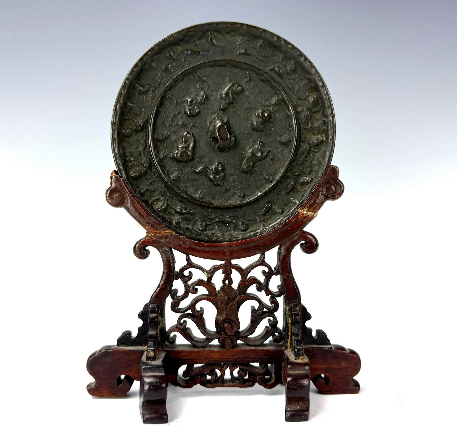 Antique Chinese Bronze Mirror with Fantastic Animals Amid Grape Vines: Antique Chinese Bronze Mirror with fantastic animals amid grape vines,with Wood Base H 19 cm(7.5 in.),Mirror diam. 11.6 cm (4.5in.). Preview from Aug 24th to 28th from 1:00 PM TO 5:00 PM Eastern Time,