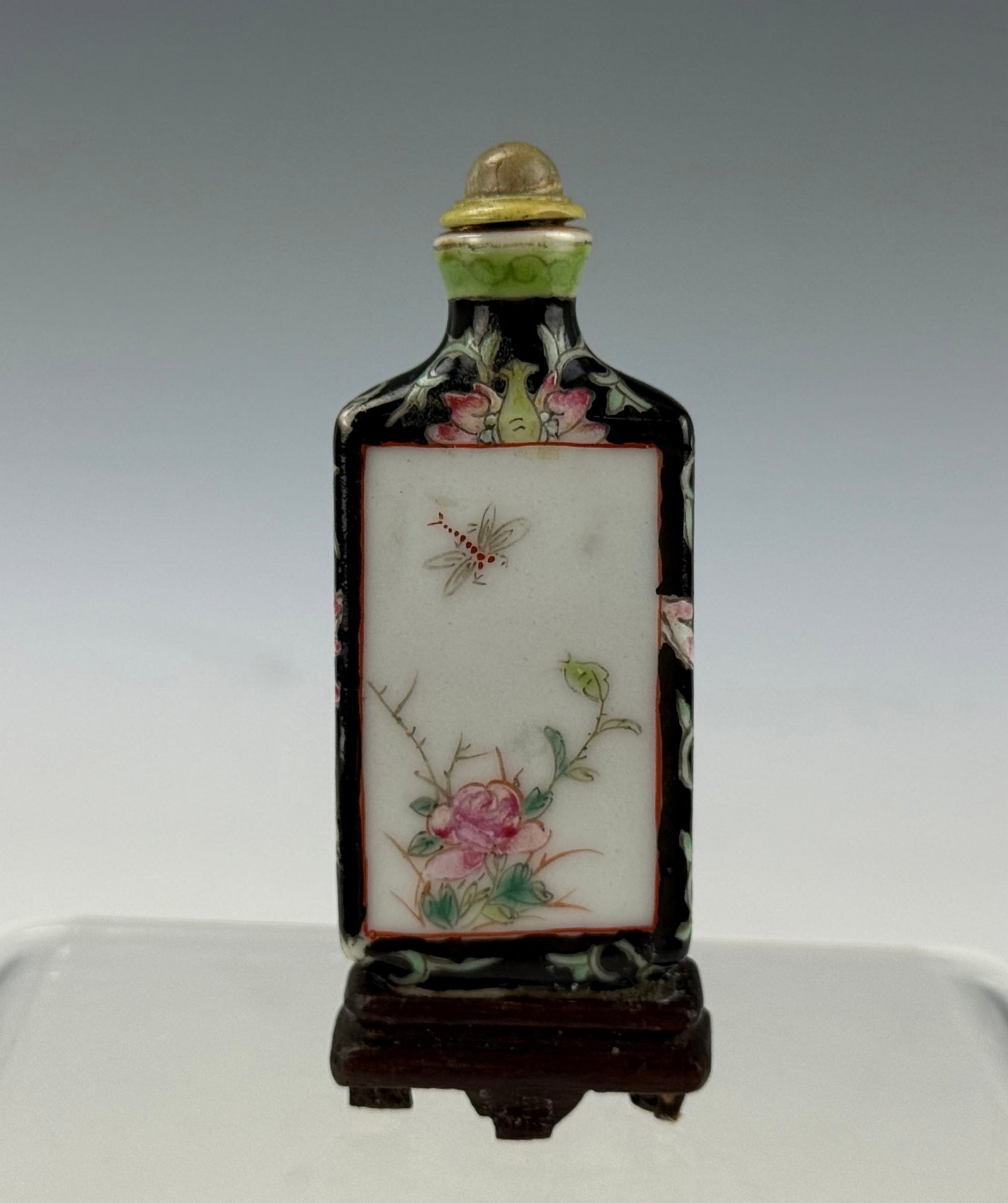 Chinese Famille Rose Porcelain Snuff Bottle with Hongxiqn Mark: Chinese Famille Rose Porcelain Snuff Bottle with Hongxiqn Mark, Floral Panel and Ornamental Border,with wood stand. H 7 cm(2.7 in.). Preview from Aug 24th to 28th from 1:00 PM TO 5:00 PM Eastern Time,