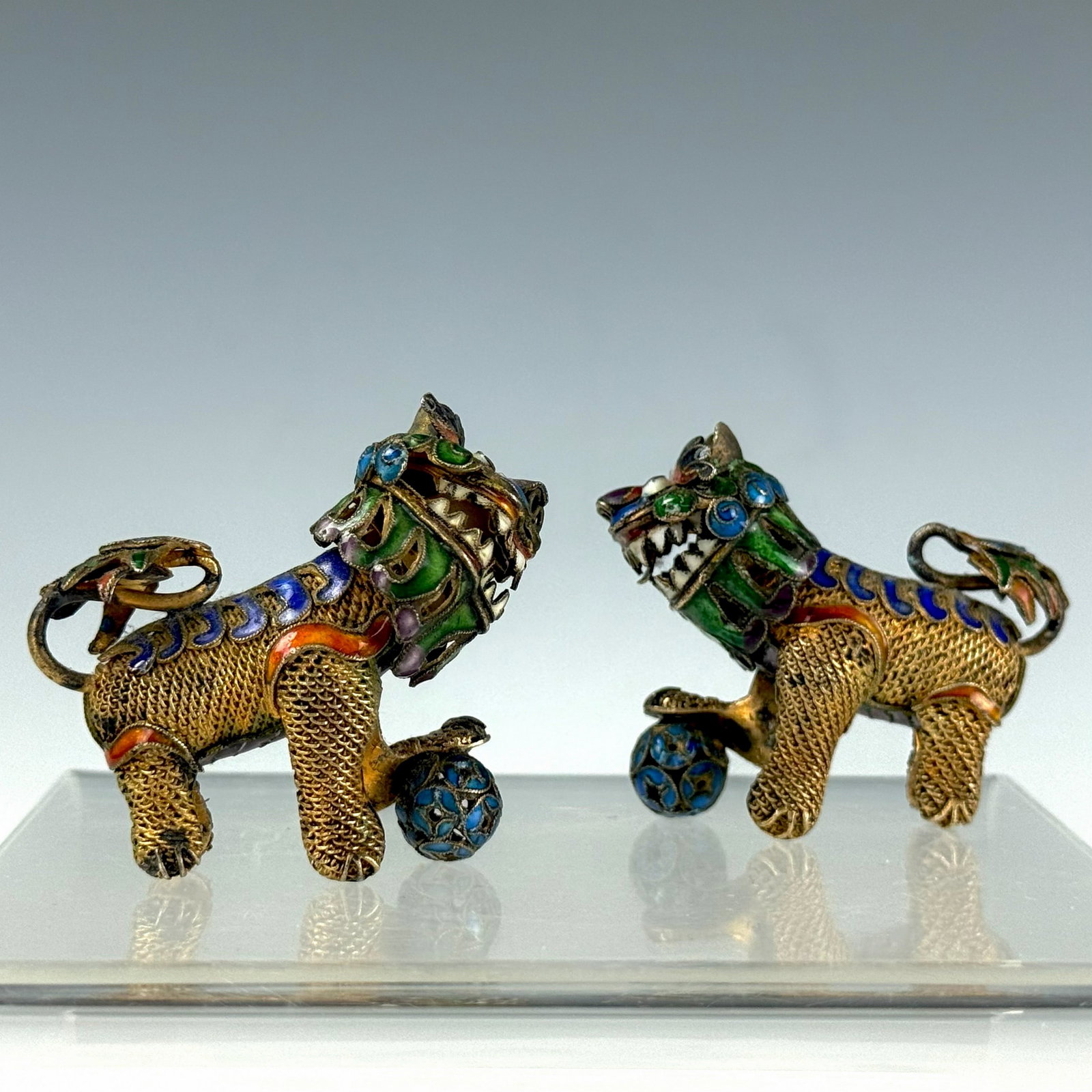 Pair of small Cloisonne Guardian Lion Figurines: Pair of small Cloisonne Guardian Lion Figurines with Polychrome Enamel and Orbs. L 4.3 cm(1.7 in.). Preview from Aug 24th to 28th from 1:00 PM TO 5:00 PM Eastern Time, Location: 15229 Display Court,