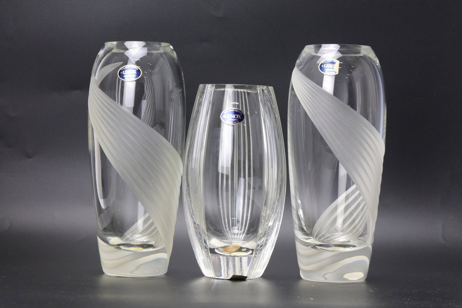 Set of Three Lenox Full Lead Crystal Vases: Set of Three Lenox Full Lead Crystal Vases Two Swirl Pattern and One Vertical Rib Triumph Small Vase. H 18.5 cm(7.5 in.), 22 cm(8.6 in.). Preview from Aug 24th to 28th from 1:00 PM TO 5:00 PM Eastern 