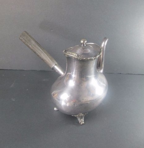 Reed & Barton Soldered Silver Teapot: DESCRIPTION: A Reed & Barton soldered silver teapot. Rests on for arching acanthus leaf motif scrolled feet embellished with scrolled verdant accents along the hinged lid. Finished with a wooden handl