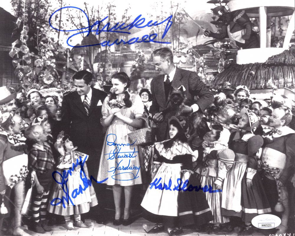 "The Wizard Of Oz" 8x10 Photo Cast-Signed by (4) with: Photo measures 8" x 10" in size and has been hand-signed by (4) including Mickey Carroll (D. 2009), Jerry Maren (D. 2018), Donna Stewart-Hardaway (D. 2008) and Karl Slover (D. 2011). The lot / autogra