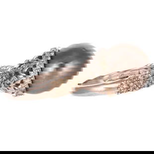 A Black South Sea Pearl & Diamond Ring in 18K: 18K white gold ring featuring a black South Sea pearl with good luster and few blemishes set in a tall bead set round diamond basket setting with two rows of shared prong set round diamonds on a high