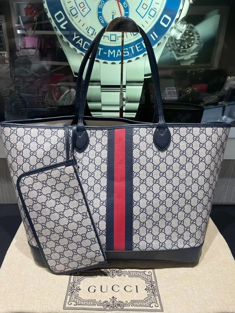 Gucci Navy GG Supreme Tote with Red/Navy Web & Matching Wristlet: Condition: Pre-owned - Good,Brand: Gucci,Accessories: Wristlet,Department: Women,Exterior Color: Navy,Style: Tote,Exterior Material: Supreme CanvasThis pre-owned Gucci Navy GG Supreme Tote with matchi