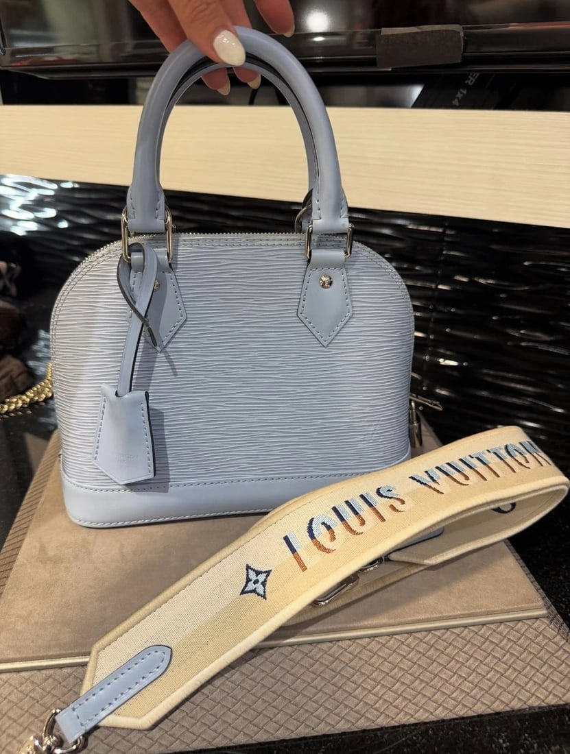 Louis Vuitton Alma BB Bleu Nuage Epi Leather with Canvas Strap: Condition: Pre-owned - Excellent,Bag Width: 9.3 in,Closure: Zip,Bag Height: 7 in,Handle Style: Shoulder Strap,Size: Small,Lining Material: Leather, Canvas,Hardware Color: Silver,Bag Depth: 4.5 in,Exte