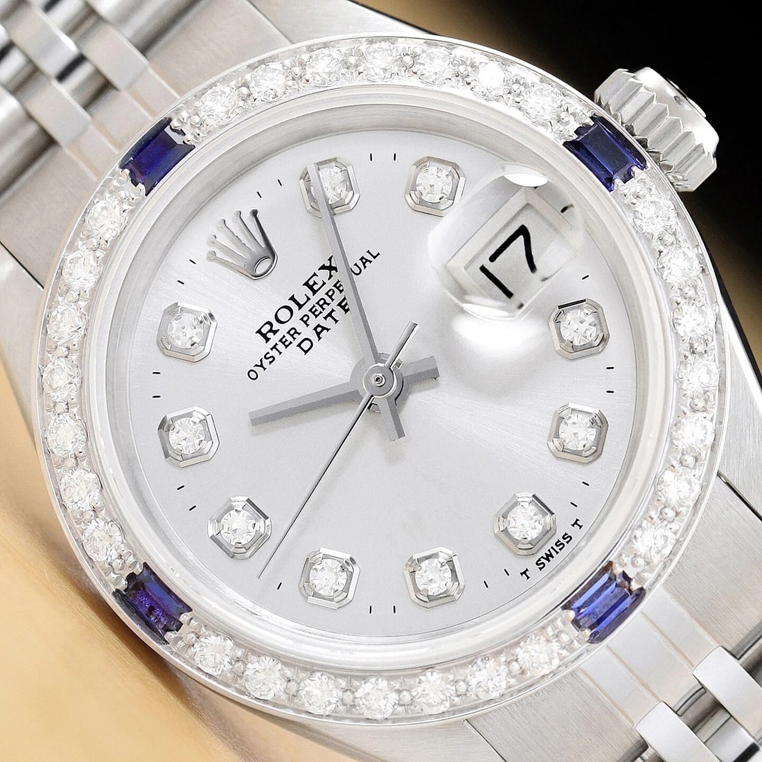 LADIES ROLEX DATE 6917 SILVER DIAL 18K WHITE GOLD SAPPHIRE DIAMOND STEEL WATCH: This is an authentic Rolex Datejust 6917 watch with Rolex dial Ref. with added genuine diamond markers, custom 18K white gold sapphire diamond bezel, and custom stainless steel jubilee band. Descripti