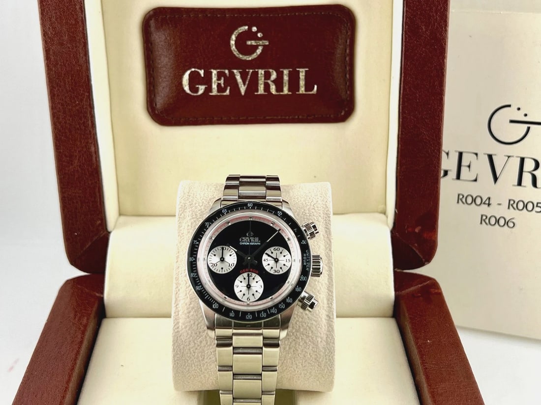 Gevril Tribeca Paul Newman R004 A9508.A.ACC 37mm Black Dial Steel Box: Style Number: A9508.A.ACCSerial: 0**/500Year: Circa 1999 - Early 2000's Model: Gevril Tribeca Paul Newman Case Material: Stainless Steel Band: Stainless Steel Bezel: Black Dial: Black Crystal: Acrylic