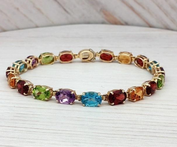 Multi-Stone Colorful Tennis Bracelet In 14k Yellow Gold.: The oval-shaped stones are 5mm wide and 6.7mm long, with a total of 19 gemstones adorning the 7-inch bracelet. . Condition: Pre-owned - Good,Antique: No,Closure: Box,Occasion: Anniversary, Birthday,