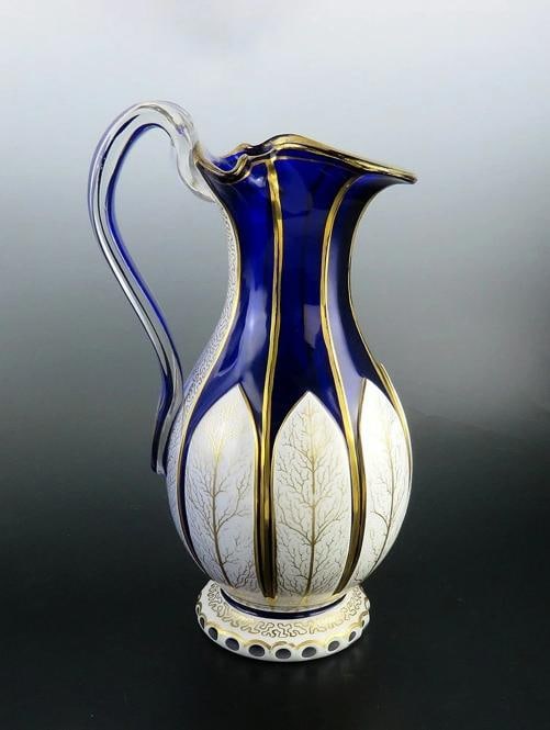 Antique Bohemian Cased Glass Gilded White on Cobalt Blue Pitcher Ewer: a stunning, hand-blown cased-glass pitcher made in Bohemia (Czech Republic) sometime in the 1850's through the 1880's. This gorgeous antique ewer, which is in wonderful condition, is a statement in