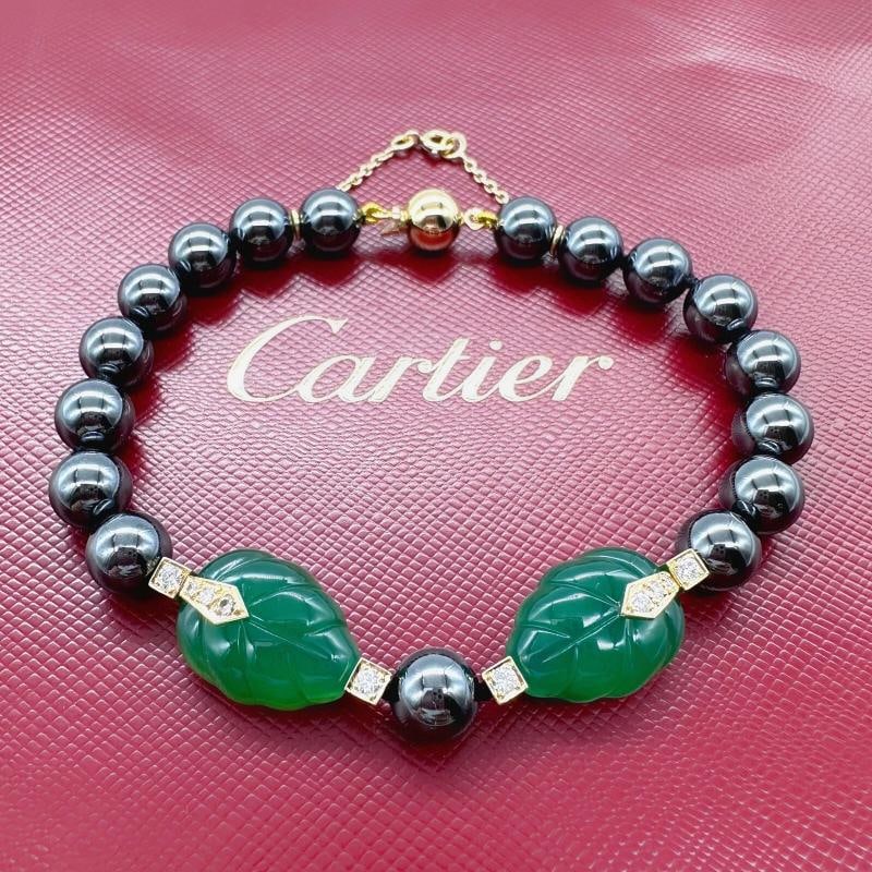 Cartier Patiala Hematite Beads with Carved Green Chalcedony Leaves Bracelet YG: Metal: 18kt Yellow Gold Size: 8' inches Closure: Ball with safety chain Hallmark: ‚©Cartier 1990 750 Cartier 999254 Includes: Cartier Pillow & Pouch for Jewelry - Recent
