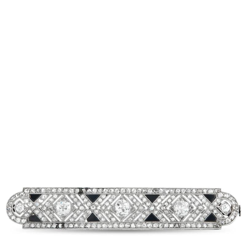 French Antique 18K White Gold 2.0ct Diamond and Onyx Brooch: sparkling Diamonds totaling 2.0 carats. Onyx accents offer beautiful contrast from their place within the 18K White Gold setting. It measures 2.50 long by 0.50 wide. Condition: Pre-owned - Good: This