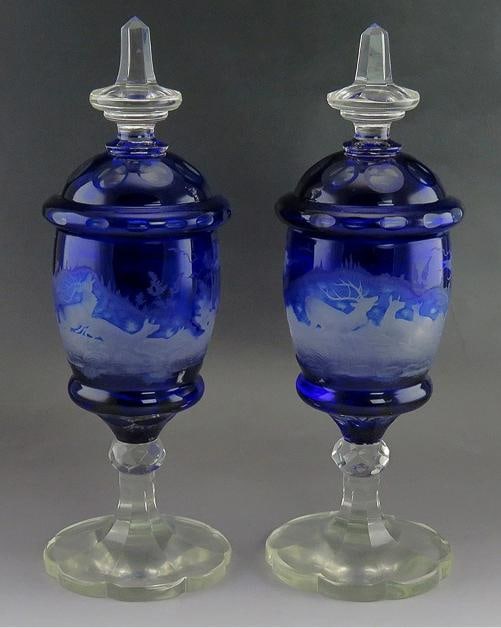 Rare Antique 1860s Bohemian Cut Glass Forest Wildlife Theme Covered Urns: a unique pair of antique Bohemian cut to clear glass urns made during the 1860s or 1870s. The covered urns are a very unique color for this type of glass. The body of each urn is beautifully and finel