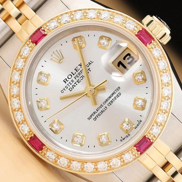 ROLEX LADIES DATEJUST 69173 SILVER DIAMOND RUBY 18K YELLOW GOLD STEEL WATCH: This is an authentic Rolex Datejust 69173 watch with Rolex 18K yellow gold and stainless steel jubilee bracelet, Rolex dial Ref. with added diamond markers, and custom 18K yellow gold diamond and ruby
