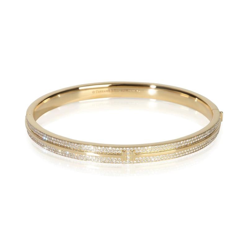 Tiffany & Co. Yellow Gold Diamond Tiffany T Hinged Bangle Bracelet: Condition: Pre-owned - Good,Shape: Round Brilliant,Item Length: 7 in,Clasp/Buckle Type: Box with Tongue,With Papers: Yes,Side Stone Type: Diamond,Side Stone Weight (cts): 0.82,Metal Purity: 18k,With