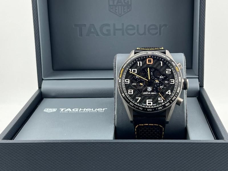 Tag Heuer Carrera McLaren Limited Edition CAR2080.FC6286 43mm 606/1000 with Box: Style Number: CAR2080.FC6286 Serial: RMG**** Model: TAG Heuer Carrera McLaren Limited Edition (Only 1000 Made) Case Material: Titanium Band: Leather. Logo on missing on the buckle Bezel: Black Dial: