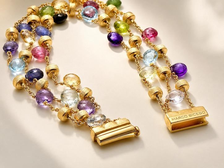 Marco Bicego Paradise Multi-Gemstone Triple Strand Bracelet 18k Yellow Gold 7 in: Metal: 18K Yellow Gold Gemstones: Blue Topaz and semi-precious gemstones that can include tourmaline, quartz, garnet and peridot Measurements: Approximately 7" Length (please refer to photos for exact