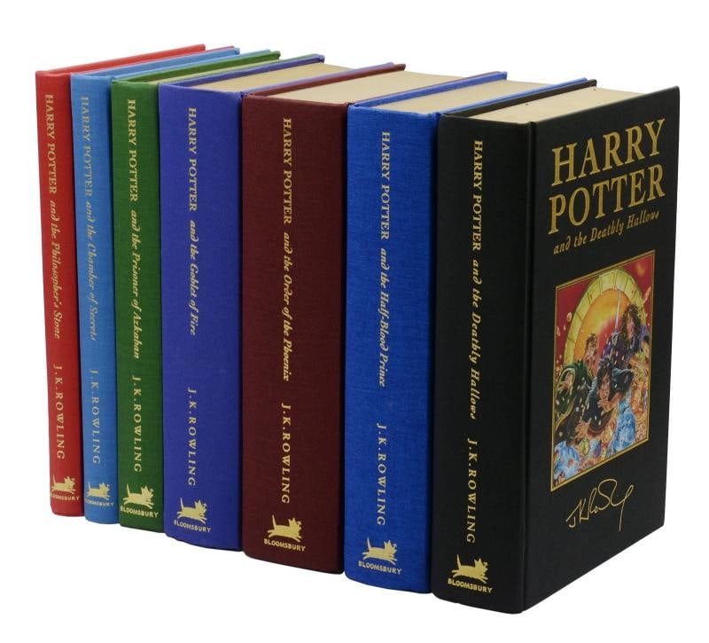 Harry Potter by J.K. ROWLING ~ Complete First Deluxe Edition Set ~ 1st: London: Bloomsbury, 1999-2007. First deluxe editions, first impressions, of the complete Harry Potter series. Complete in seven volumes bound in cloth with color pictorial onlays, gilt edges, ribbon
