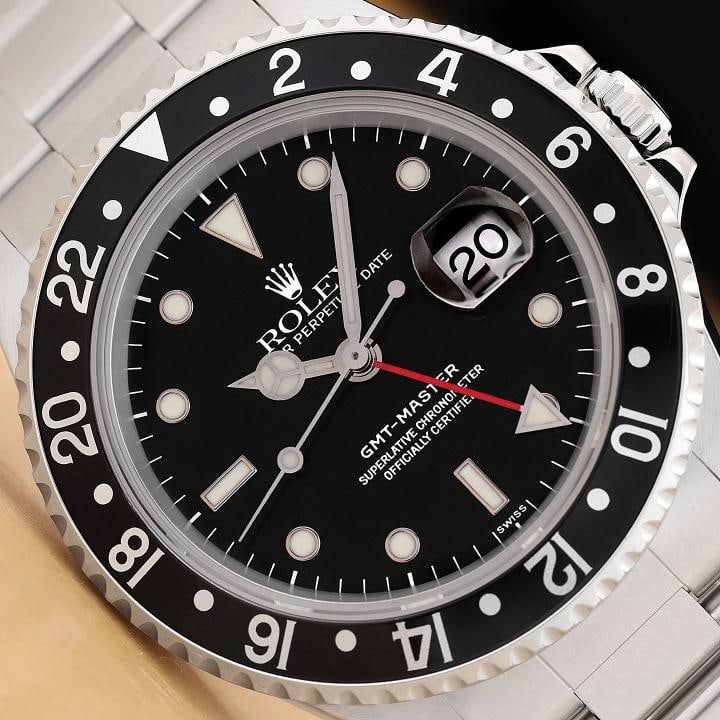 ROLEX MENS GMT MASTER 16700 STEEL DATE BLACK DIAL OYSTER 40MM WATCH w/ PAPER: This is an authentic Rolex 16700 GMT Master 40mm black dial watch with black rotatable bezel, stainless steel oyster bracelet, and original Rolex paper. This genuine pre-owned timepiece is in great