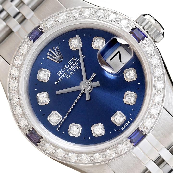 LADIES ROLEX DATE 6917 DIAMOND SAPPHIRE 18K WHITE GOLD STEEL BLUE DIAL WATCH: This is an authentic Rolex Datejust 6917 watch with Rolex dial Ref. with added genuine diamond markers, custom 18K white gold sapphire diamond bezel, and custom stainless steel jubilee band.