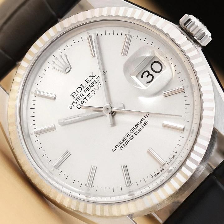 ROLEX MENS DATEJUST 16014 18K GOLD STEEL SILVER DIAL BLACK LEATHER BAND WATCH: This is an authentic Rolex Datejust 16014 watch with Rolex stick dial Ref., Rolex 18K white gold fluted bezel, and custom genuine black leather strap. Descriptions: Brand: Rolex Model: Datejust Refere