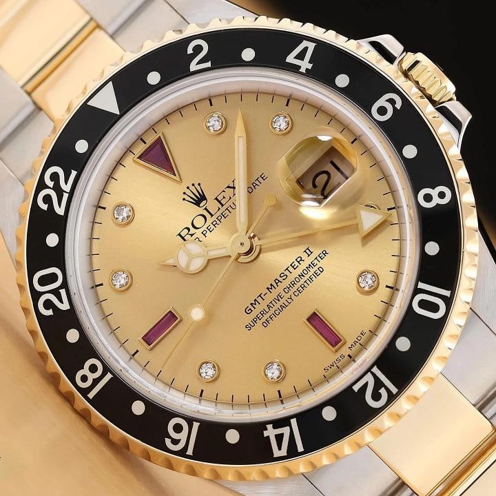 2007 CARD ROLEX GMT MASTER II 40MM 16713 SERTI RUBY DIAMOND 18K GOLD STEEL WATCH: This is an authentic Rolex GMT Master II 16713 40mm serti ruby diamond dial watch with black rotatable 18K yellow gold bezel, and 18K yellow gold stainless steel oyster bracelet, and Rolex warranty