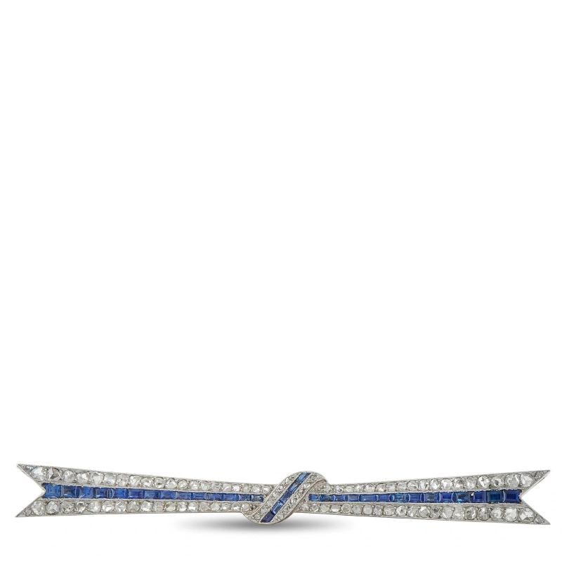 18K White Gold 2.10ct Diamond and Sapphire Art Deco Bow Brooch: crafted in 18K white gold in a stylized ribbon bow motif, pave-set with rose-cut diamonds totaling approximately 2.10 carats and channel-set sapphires totaling approximately 1.00 carat. Weighing appro