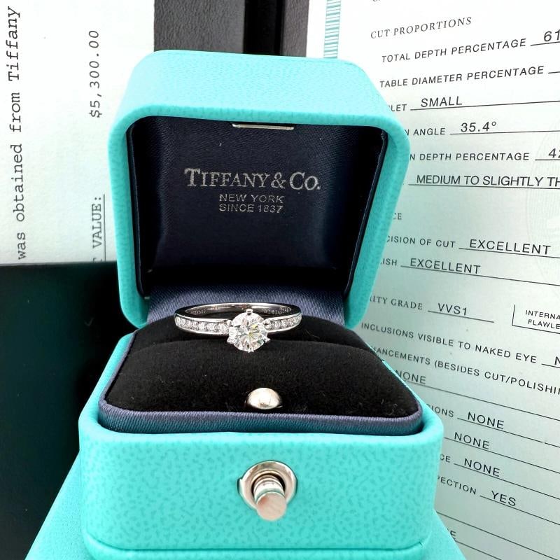 Tiffany & Co Platinum Diamond Engagement Ring Round 0.60 ct I VVS1: Condition: Pre-owned - Excellent,Number of Diamonds: 15,Main Stone Creation: Natural,Signed: Yes,Color: White,Cut Grade: Excellent,Sizable: Yes,Main Stone Color: White/Colorless,Metal: Platinum,Total