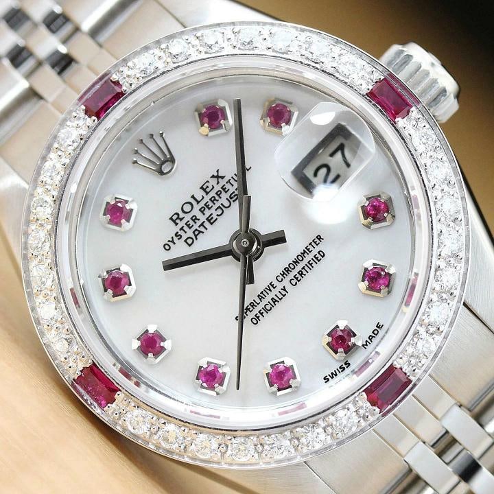 ROLEX LADIES DATEJUST 69174 MOTHER OF PEARL RUBY DIAMOND 18K WHITE GOLD/SS WATCH: This is an authentic Rolex Datejust 69174 watch with Rolex stainless steel jubilee band, Rolex dial Ref. with added genuine mother of pearl and ruby markers, and custom 18K white gold ruby diamond bez