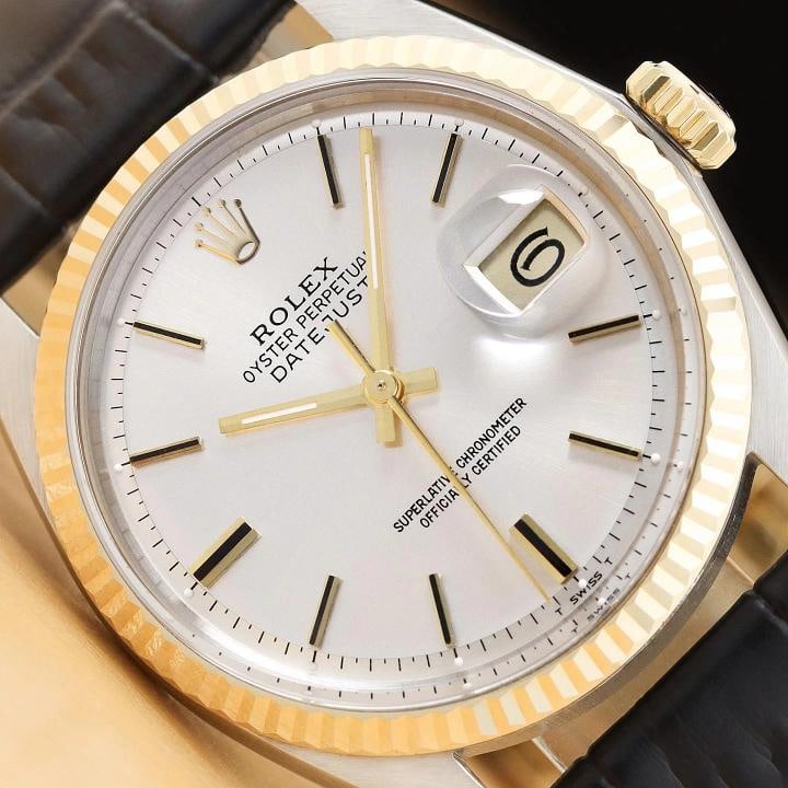 ROLEX DATEJUST 1601 SILVER 14K YELLOW GOLD STEEL BLACK LEATHER BAND WATCH: This is an authentic Rolex Datejust 1601 watch with Rolex stick dial Ref., Rolex 14K yellow gold fluted bezel, and custom genuine black leather bracelet. Descriptions: Brand: Rolex Model: Datejust