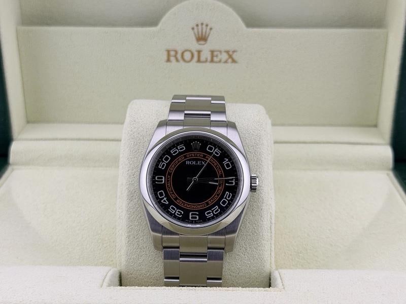 Rolex Oyster Perpetual 116000 36mm Black Orange Concentric Harley Dial Box: Style Number: 116000 Serial: M89**** Year: 2008 Model: Rolex Oyster Perpetual Case Material: Stainless Steel Band: Stainless Steel Bezel: Stainless Steel Dial: 'Harley Dial' - Black & Orange