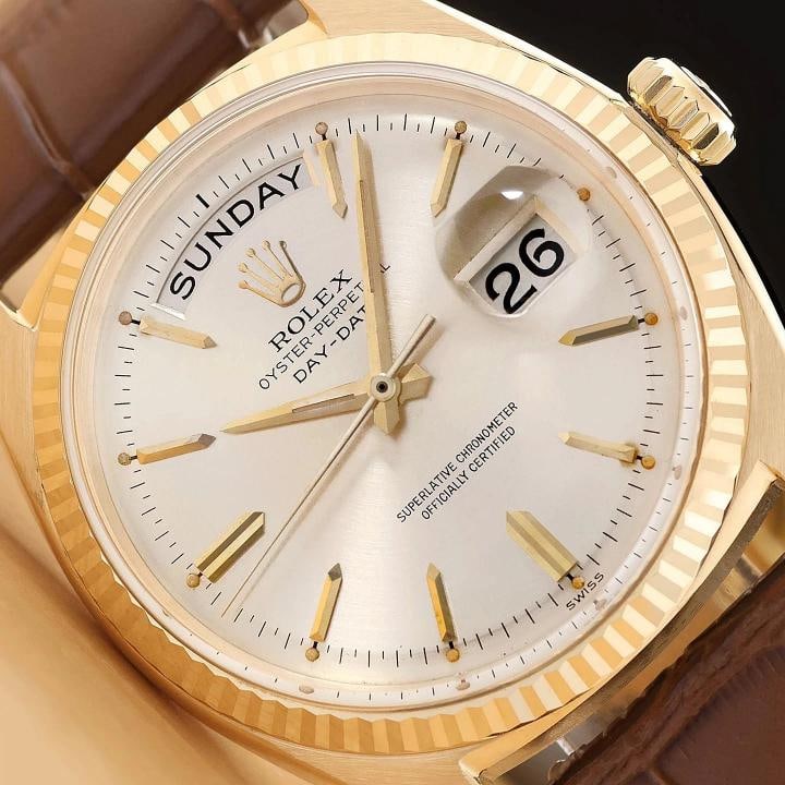 ROLEX MENS DAY-DATE 1803 18K YELLOW GOLD SILVER DIAL BROWN LEATHER WATCH: This is an authentic Rolex Day-Date 1803 watch with Rolex stick dial, Rolex 18K yellow gold fluted bezel, and custom genuine brown leather bracelet. Descriptions: Brand: Rolex Model: Day-Date Referenc