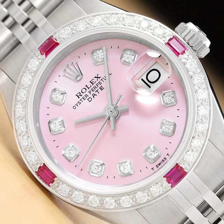 LADIES ROLEX DATE PINK RUBY DIAMOND 18K WHITE GOLD STAINLESS STEEL WATCH: This is an authentic Rolex Datejust 6917 watch with Rolex dial Ref. with added genuine diamond markers, custom 18K white gold ruby diamond bezel, and custom stainless steel jubilee band. Descriptions:
