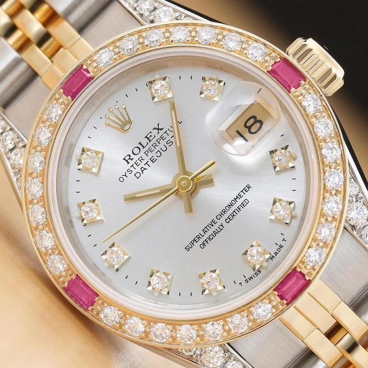 ROLEX LADIES DATEJUST 69173 SILVER FACTORY DIAMOND RUBY 18K GOLD STEEL WATCH: This is an authentic Rolex Datejust 69173 watch with Rolex 18K yellow gold and stainless steel jubilee bracelet, factory Rolex diamond dial Ref., custom 18K yellow gold ruby diamond bezel, and added d