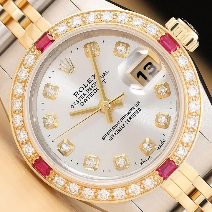 ROLEX LADIES DATEJUST 69173 SILVER DIAMOND RUBY 18K YELLOW GOLD STEEL WATCH: This is an authentic Rolex Datejust 69173 watch with Rolex 18K yellow gold and stainless steel jubilee bracelet, Rolex dial Ref. with added diamond markers, and custom 18K yellow gold diamond and
