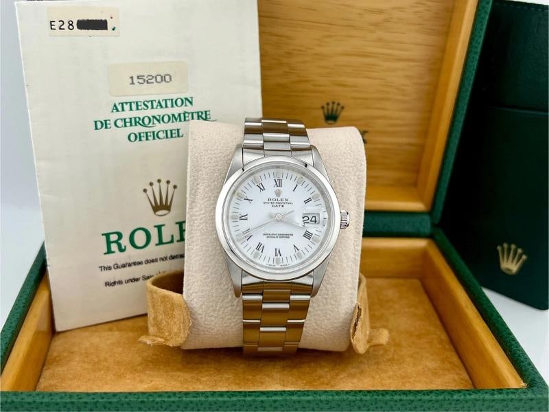 Rolex Date 15200 34mm White Roman Dial Stainless Steel Box Papers: Style Number: 15200 Serial: E28**** Year: 1990 Model: Rolex Date Case Material: 34mm Band: Stainless Steel Bezel: Stainless Steel Dial: White Roman Crystal: Sapphire Case Size: 34mm Includes: - Rolex