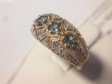 Ladies vintage style diamond and green stone ring: This ring is made from solid 14k yellow gold and features three green stones flanked by diamonds. There are 28 diamonds for a total ct weight of approx 1/4 carat. Total weight of the ring is 5.2g and