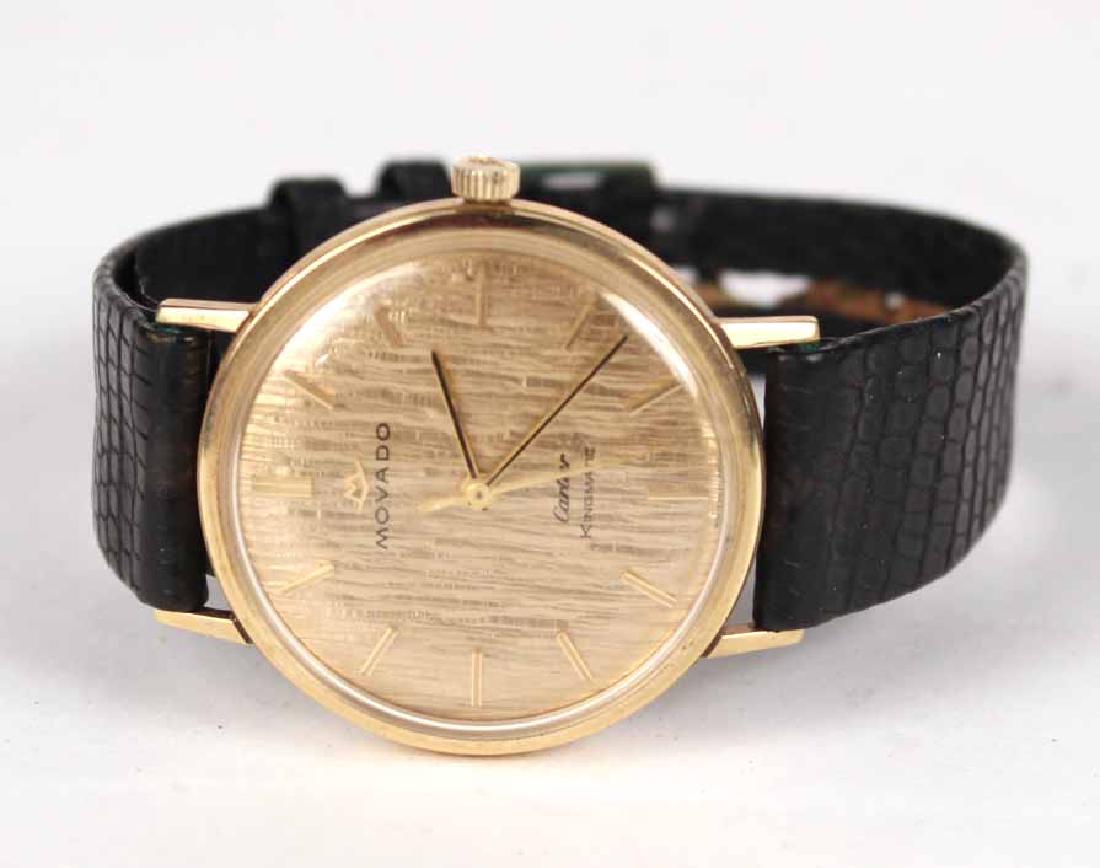 Movado 14K Yellow Gold Wristwatch: Stamped Kingmatic on dial, retailed by Cartier, gilt circular face with gilt numeral indicators, on lizard embossed leather band. Dial, 1-1/4"d