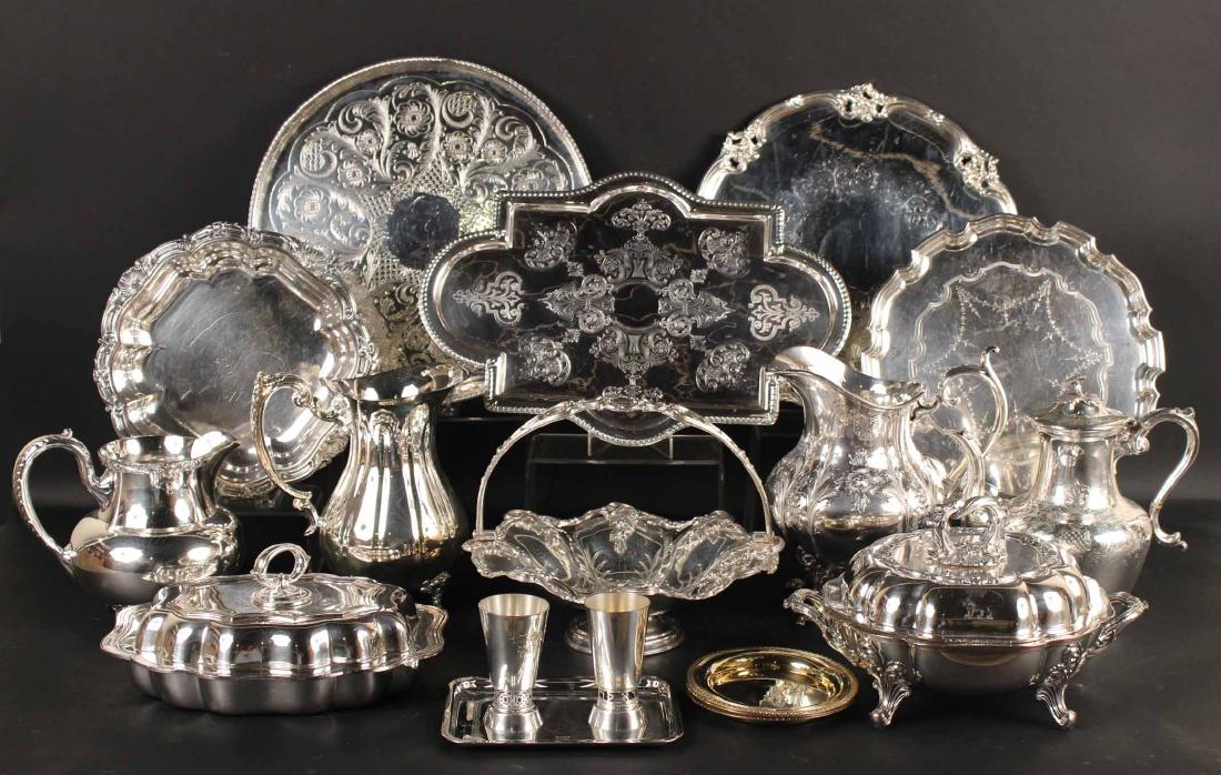 Large Group of Silver Plated Table Items: Including covered vegetable dishes, water pitchers, trays, handled basket, pair of Israeli cups, three Christofle wine coasters, and small rectangular card tray. Largest tray, 14-3/4"d Property from a