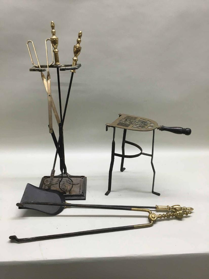 BRASS STANDING TRIVET: Resting on an iron base. Together with a set of fire tools. Trivet stands 14" tall