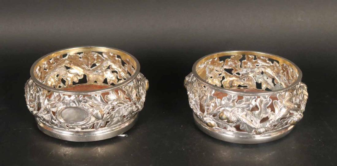 Pair of Ornate Sterling Silver Wine Coasters: Crafted by Rob Butler Silversmith, Millbrook, NY. Each with wooden bottoms, pine cone and leaf reticulate partial gilt decoration, each with vacant cartouche, total weight including wooden bases, appr