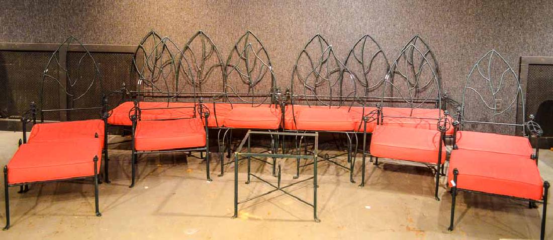 Set of Wrought-Iron Gothic-Back Outdoor Furniture: American, 20th C., with green-paint and pink cushions. Comprising, two settees, two high chairs, four low chairs, two ottomans, and a side table. 11 pieces Settee: 50"h x 6'2"w x 26"d. Property from t
