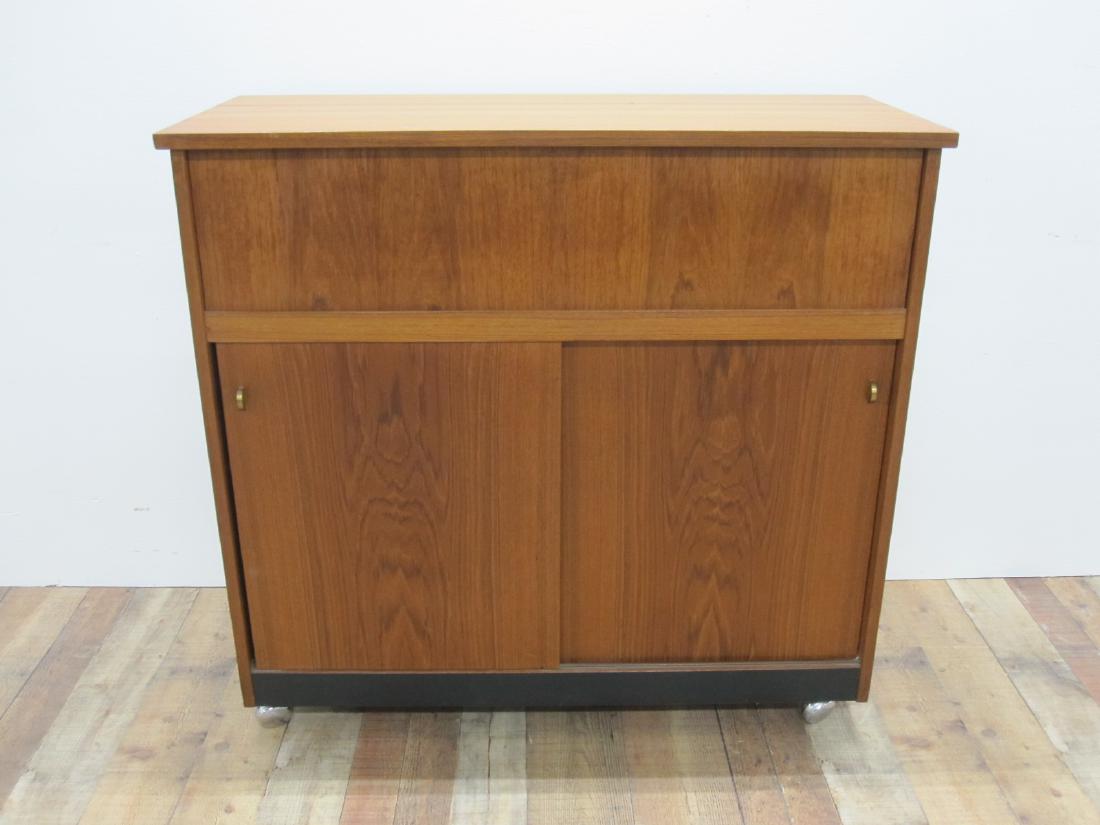 MID CENTURY LIQUOR CABINET: Having a hinged lid and slide doors. 41 1/4" long x 17 3/4" deep x 39" high