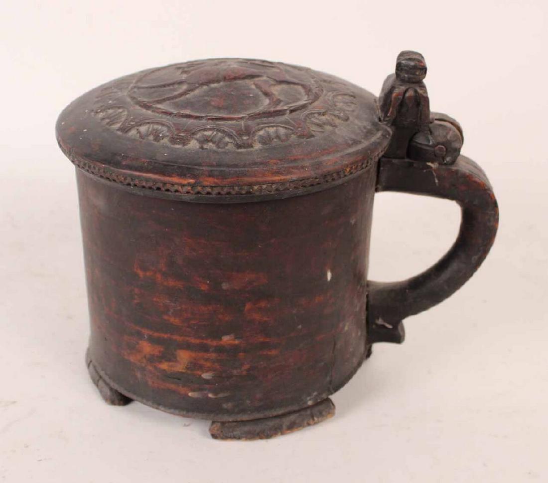 Scandinavian Turned and Craved Tankard: 18th C. The hinged cover carved with folky crowned lion, three figural feet and a figural carved handle. 8"h x 9 1/2"dia. By descent from the Estate of Robert Weeks DeForest and Emily Johnson DeForest