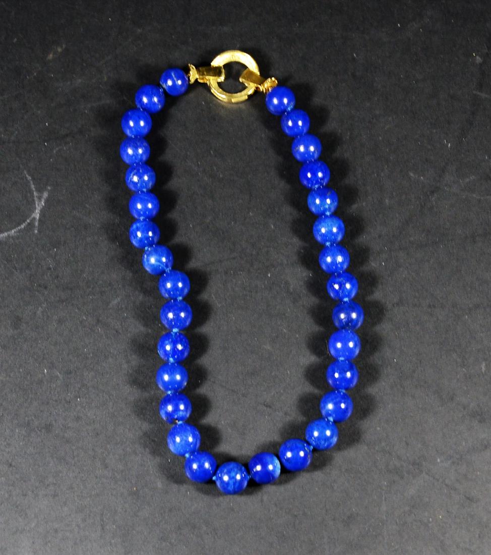 Lapsis Lazuli 13MM Beaded Necklace: With 18K yellow gold and diamond clasp. 17"l. From Claus Vollrath Inc., Mt Kisco, New York.