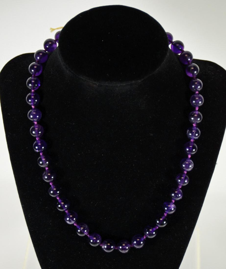 Amethyst 10MM Beaded Necklace: With 14K yellow gold clasp. 18"l. From Claus Vollrath Inc., Mt Kisco, New York.