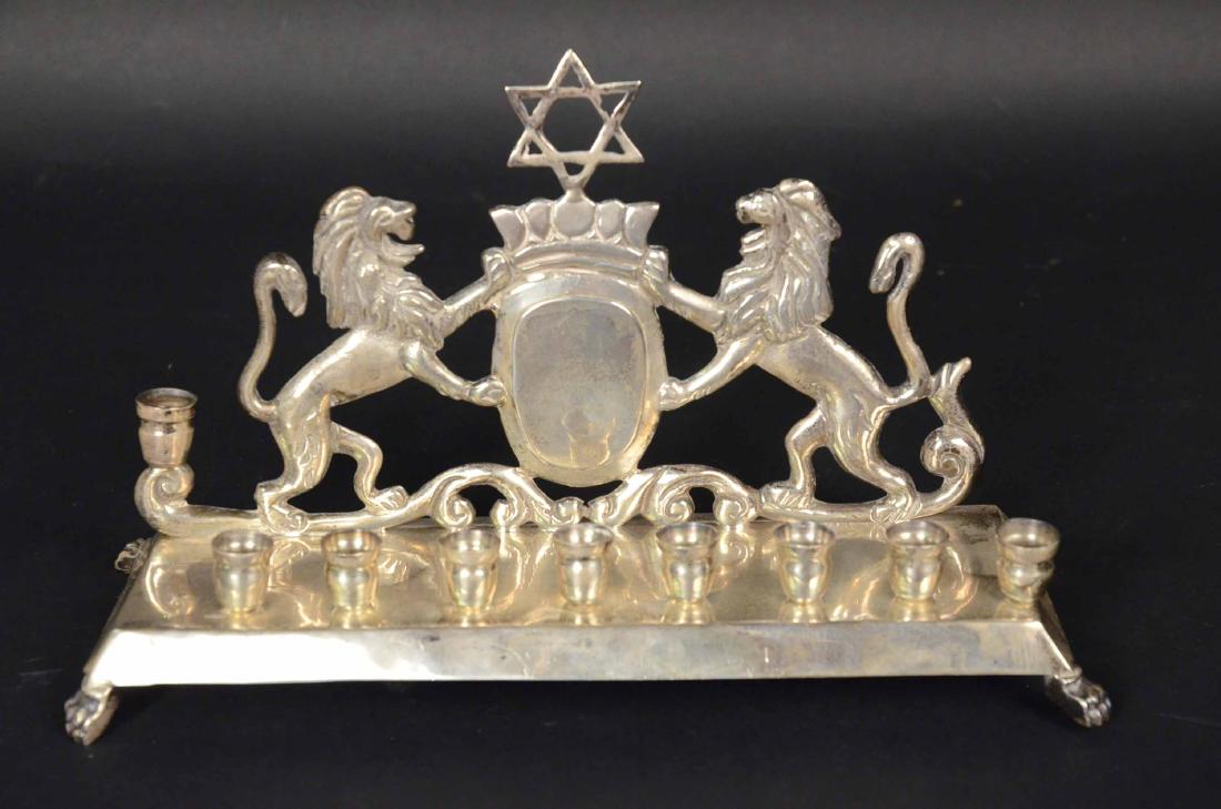 Sterling Silver Menorah: Crest flanked by Lions of Judea on rectangular base raised on claw feet, weight approx. 26 T.O. 5-1/4"h x 10-1/2"w.