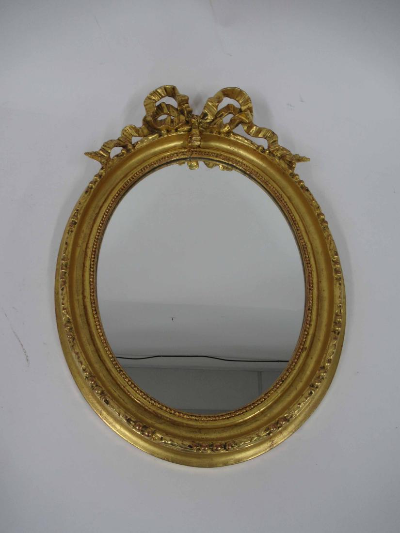 Ribbon Crest Gilt-Wood Mirror: Swedish and oval in form. 21" tall x 15 1/2" wide x 3" deep