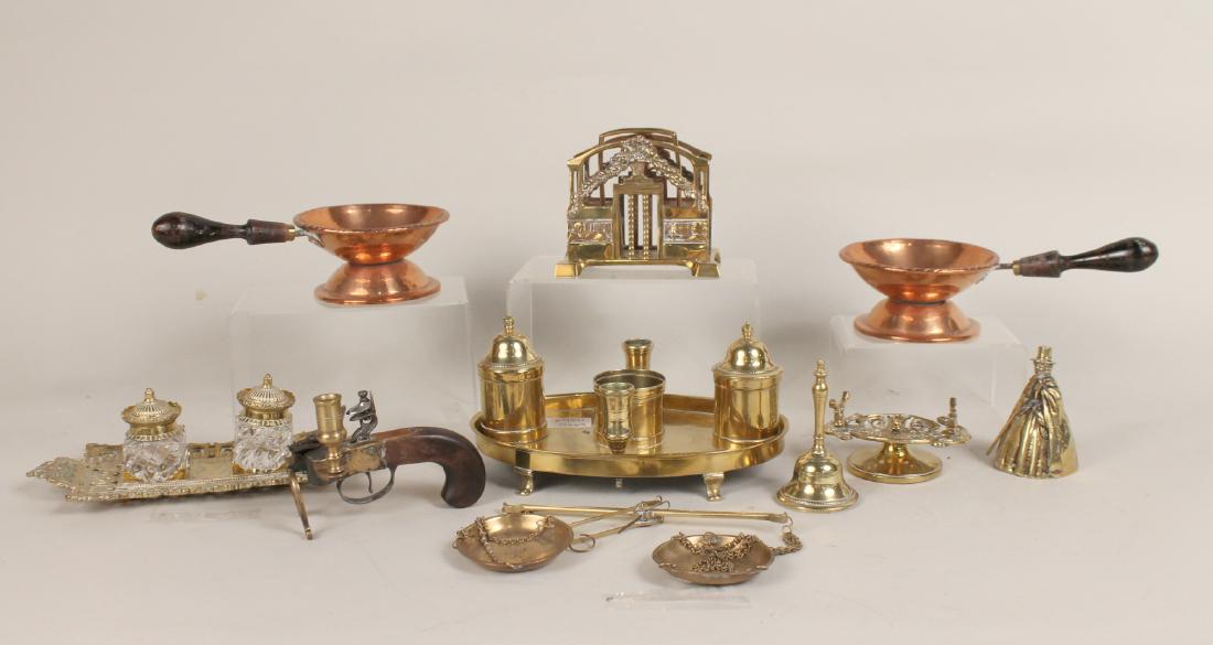 Group of Brass Desk Garnitures: Comprising a Georgian standish, brass and glass inkwells on stand, desk pen holder, double letter holder, figural bell, balance scales and pistol form candle holder. Together with two copper pipe ligh